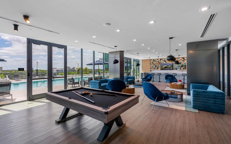 a room with a pool table and chairs
