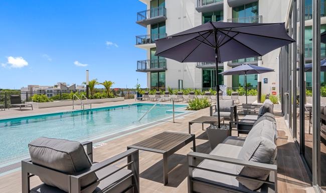 a pool with chairs and umbrellas by it